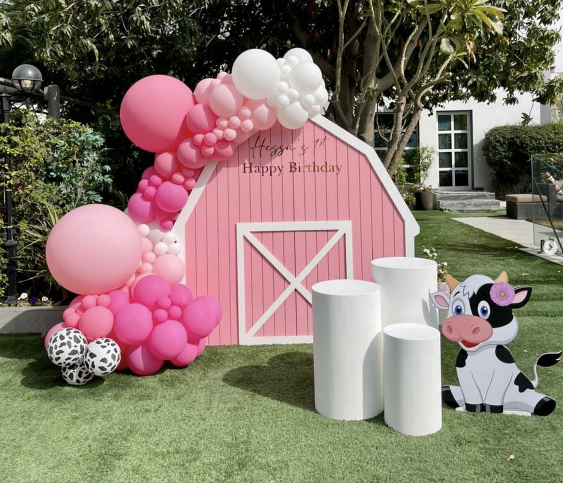 Pink barn house (Barn House backdrop 2m high- pink and white Personalization on backdrop Balloon garland 3 x white circle tables 1 x cow foam board (1m height))